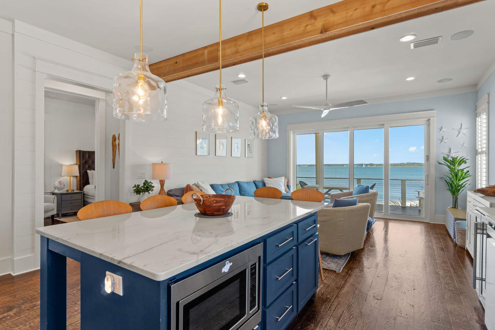 Open kitchen island and living area at Stella Maris with sliding doors overlooking Santa Rosa Sound