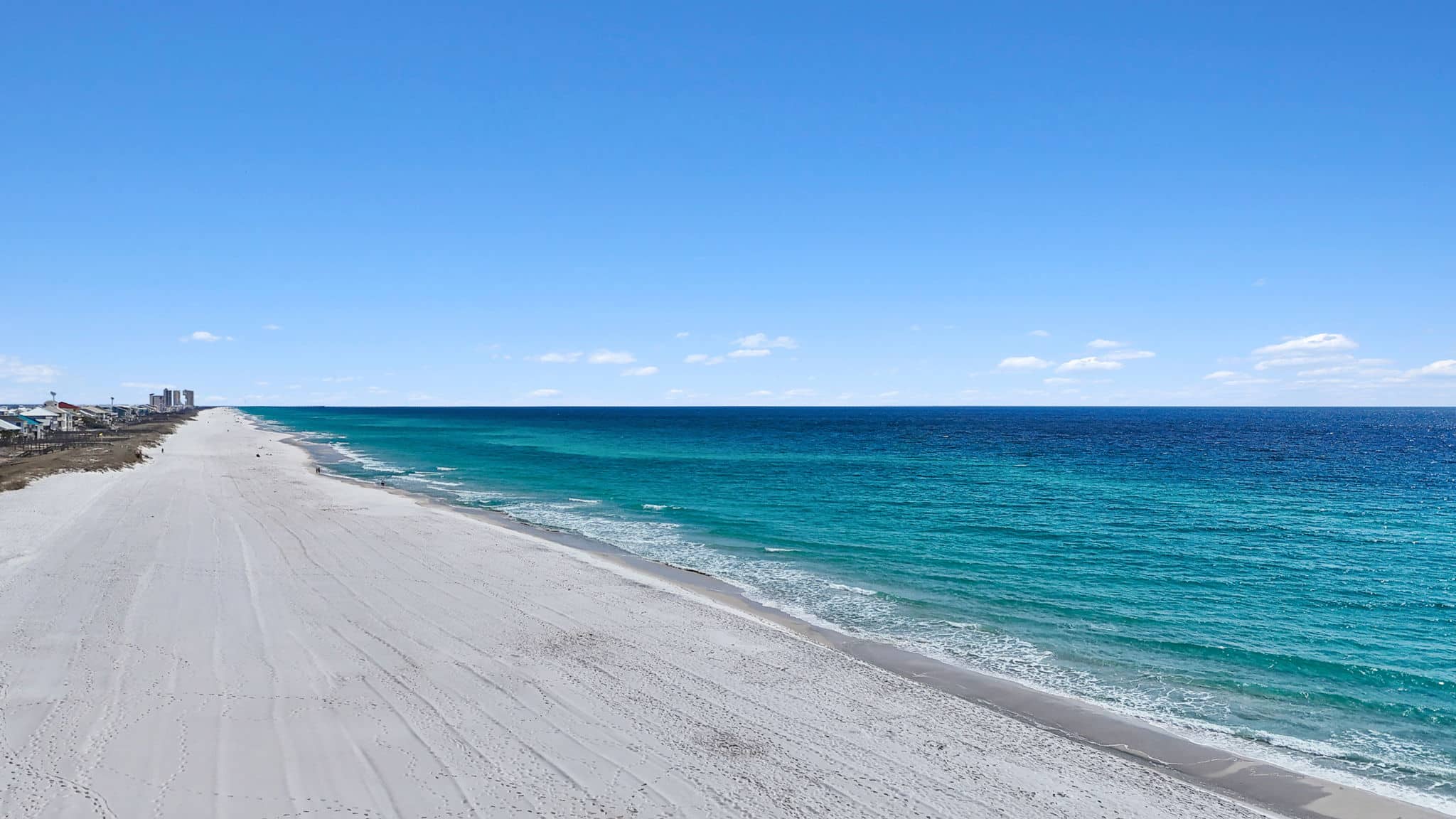 Emerald Gulf water and sugar-white sand at Navarre Beach, home to the Navarre Beach Marine Sanctuary snorkeling reefs