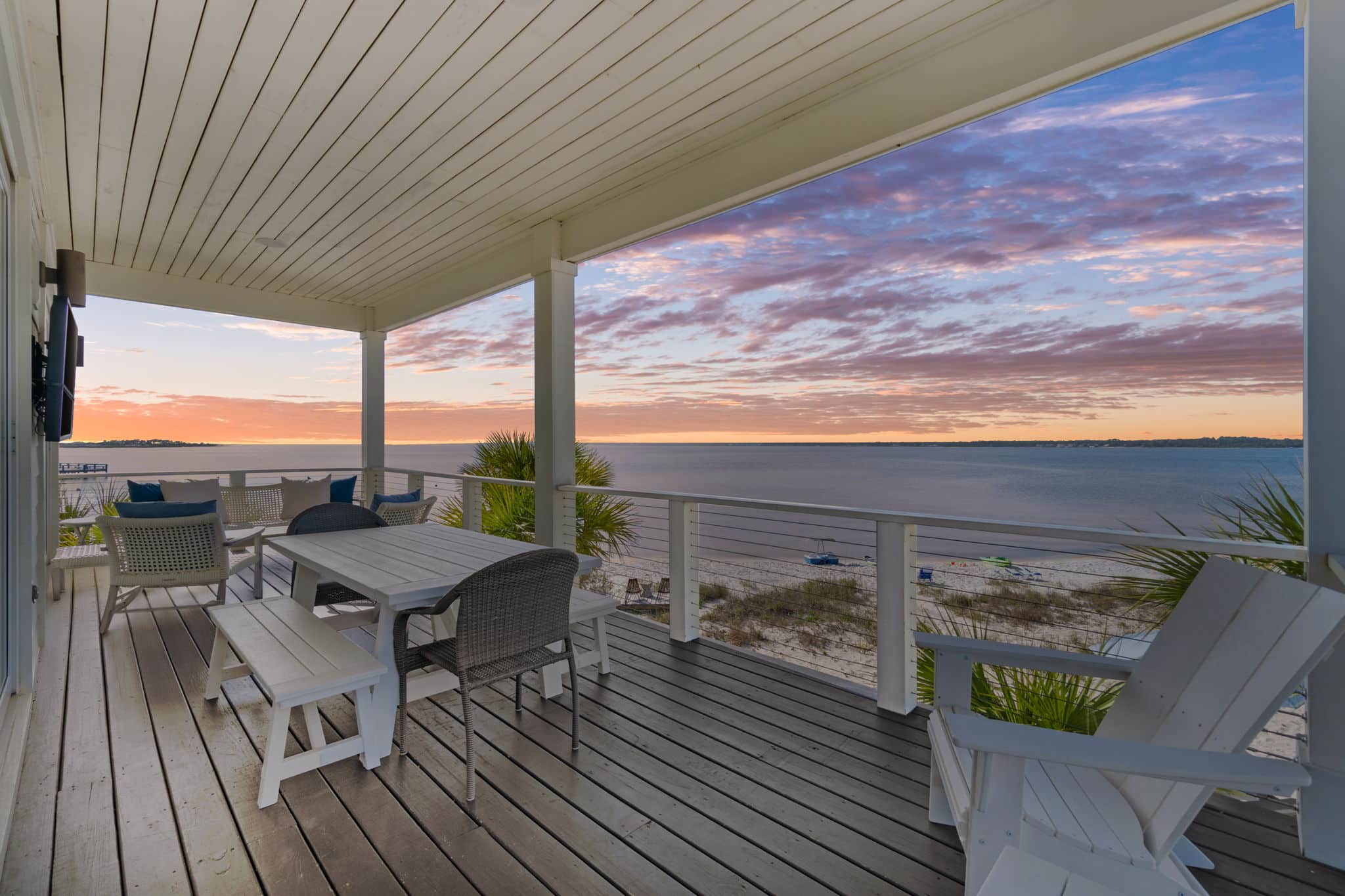 Stella Maris vacation home glowing at twilight beside Santa Rosa Sound on Navarre Beach under a darkening sky